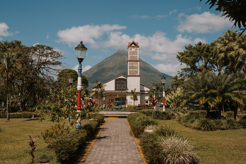 Costa Rica La Fortuna town centre with white building with tower and gardens on a sunny day