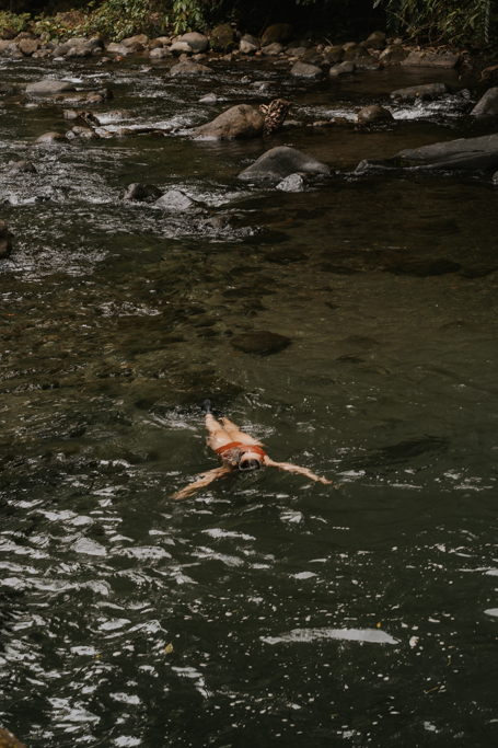 a girl in a red bathing suit floats in the waters of El Salto La Fortuna activities