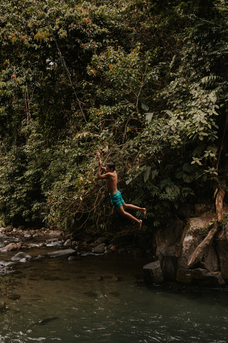 a local boy in blue shorts swings from the El Salto rope swing, of the best free things to do in La Fortuna