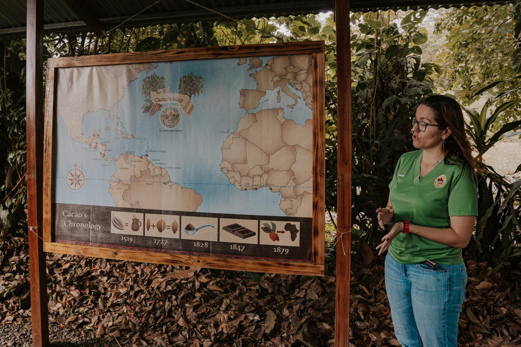 guide talking beside a map of the world on cacao tours