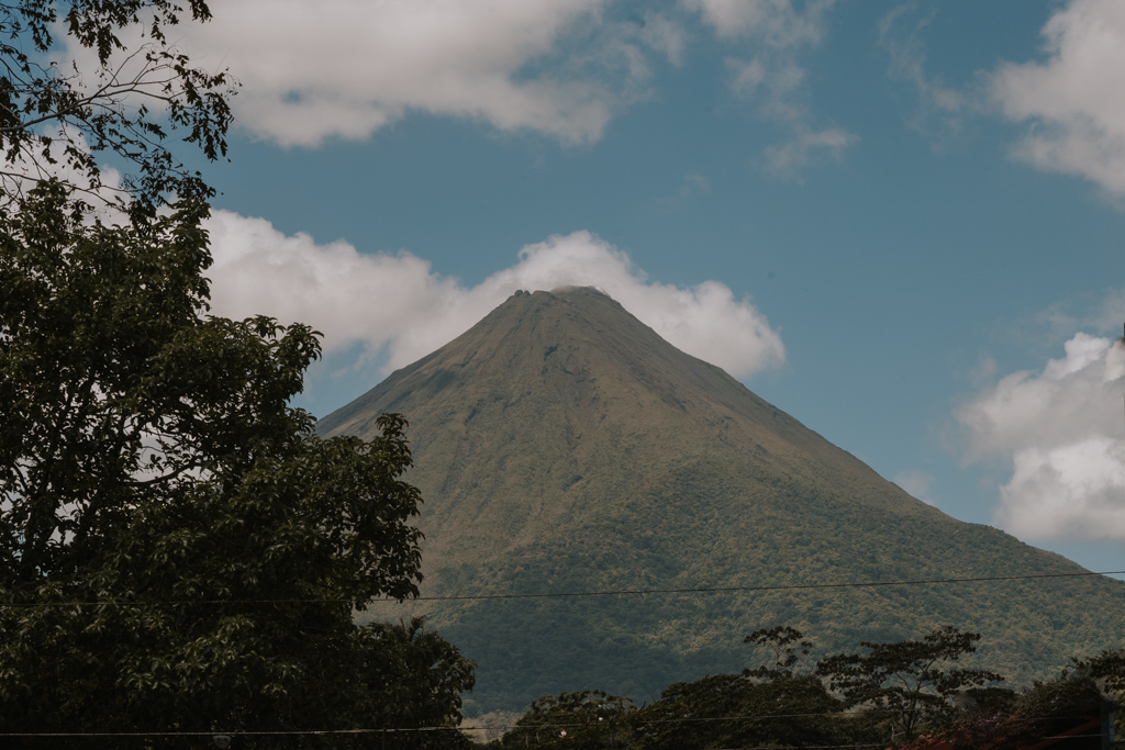 Views of Arenal Volcano on the way to Cascada La Fortuna with partly cloudy blue sky