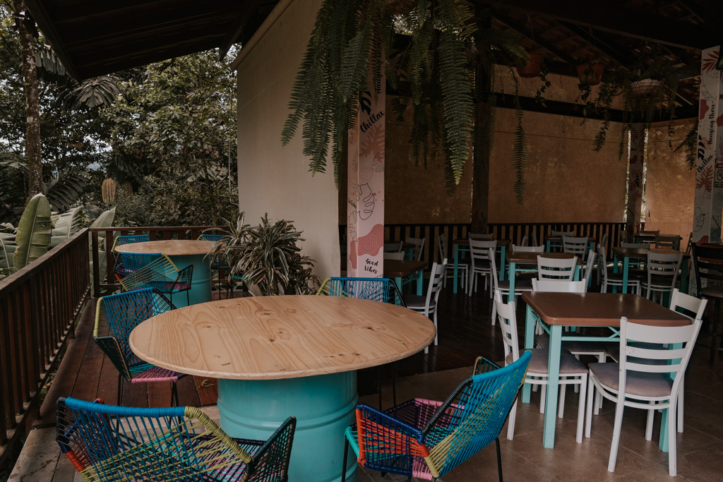 colourful seating and hanging plants in a restaurant at waterfall in Costa Rica