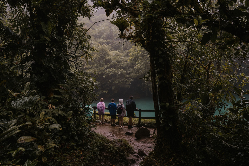 four people stand in front of the river perfect for rio celeste tubing amongst dense jungle