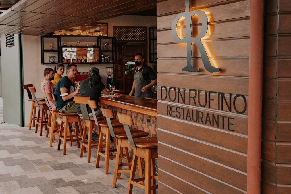 outdoor bar in one of the best restaurants arenal offers for steak with sign that reads 'don rufino restaurante' on wood siding
