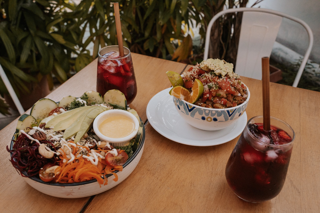 la fortuna restaurants offer healthy menus with large salad bowls and red drinks on a wooden table