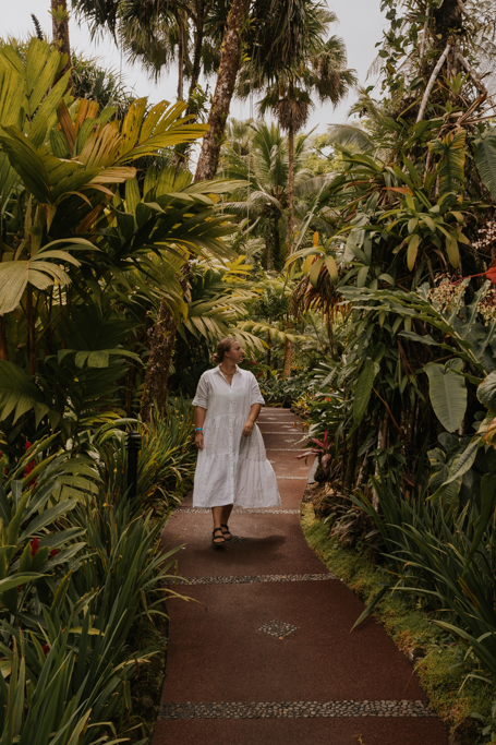 a woman in flowy white dress walks along the paths at tabacon hot springs Costa Rica