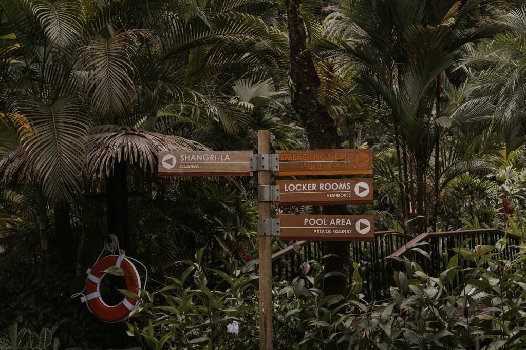 costa rica thermal springs wooden sign post with lifeguard ring and jungle